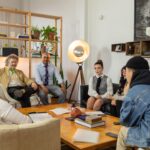 A diverse team gathered for a meeting in a modern office with creative decor, discussing plans.